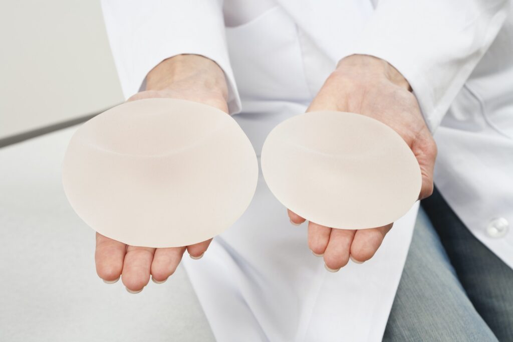 Germany, Munich, Doctor holding breast implant, close up